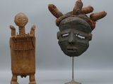 deux sculptures en bois représentant un homme et une femme, posées sur un socle