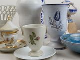 many different types of tea cups and saucers on the table