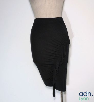 un mannequin vêtu d'une jupe noire, posé sur un pied de mannequin