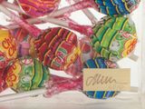 several lollipops in a glass jar with a sign on it