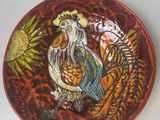 une assiette décorative représentant un coq, posée sur une table