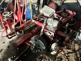 a red machine that is sitting in the dirt
