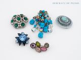 cinq broches de formes et de couleurs différentes sur un fond blanc