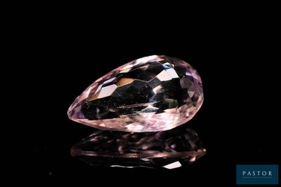 a close up of a pink diamond on a black surface