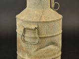 an old metal milk can sitting on top of a black table