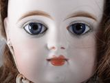 a close up of a doll ' s face with blue eyes