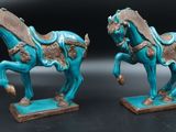 paire de figurines de chevaux émaillées de turquoise, posées sur des socles, sur fond noir