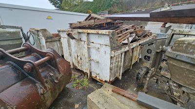 a dumpster that is sitting next to a pile of junk