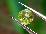 un gros plan d'un diamant jaune tenu par une paire de pinces