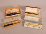 several pens and pencils are in a box on a table