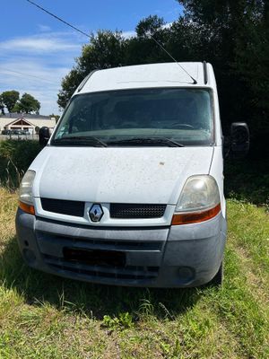 une camionnette blanche garée dans l'herbe près d'une maison