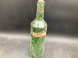 a green bottle with a brown label on it