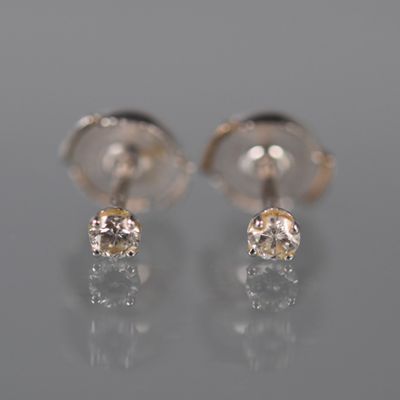 une paire de boucles d'oreilles en diamant posées sur une surface réfléchissante