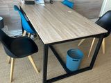 a table and chairs in a room with pictures on the wall
