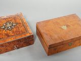 deux boîtes en bois ornées de motifs décoratifs, posées sur une table