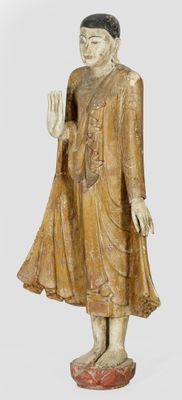 statue en bois représentant un Bouddha debout, la main levée
