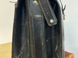 a black purse sitting on top of a wooden box