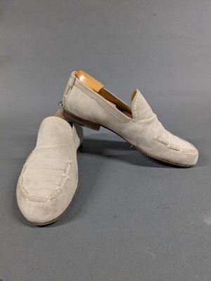 pair of men ' s white sued slippers on grey background