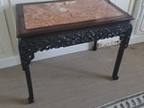 une petite table avec un plateau en marbre dans une pièce