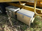 a metal box sitting in the grass next to a truck