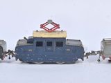 trois petits trains jouets posés côte à côte dans la neige
