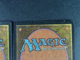 two magic the gathering cards are sitting on a table