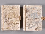 pair of antique book covers with decorative designs on them on a gray surface