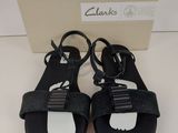 les sandales noires de Clark, avec des semelles blanches et des lanières noires