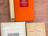 many books on a table with a pen and a book