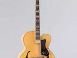 un gros plan d'une guitare posée sur un support, sur fond blanc