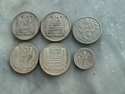 six pièces chinoises posées les unes à côté des autres sur une table