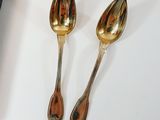 two spoons that are sitting next to each other
