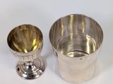 two silver cups and a silver cup on a white surface