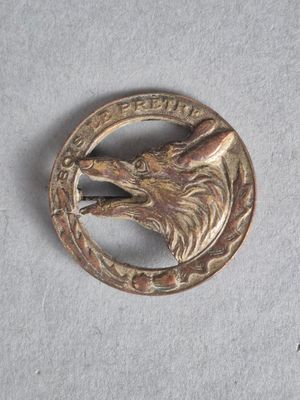 une image représentant une épingle en métal ornée d'une tête de loup