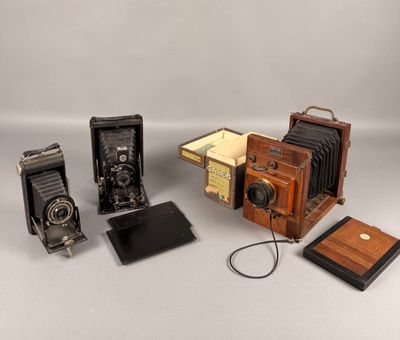Plusieurs vieux appareils photo sont posés sur une surface blanche