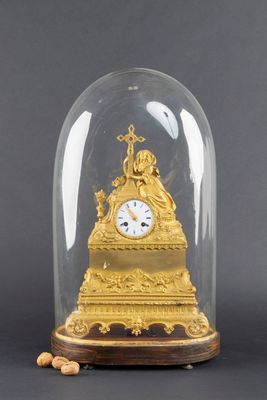 une horloge en or sous un dôme de verre sur une table