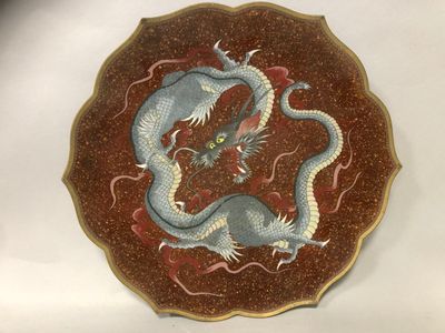 une assiette sur laquelle est représenté un dragon, posée sur une table