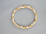 yellow and white beaded bracelet on a gray surface