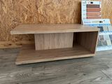 a wooden shelf with a book on it in front of a wall