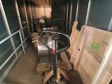 Plusieurs palettes de bois sont empilées dans un local de stockage