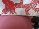 un oreiller rouge et blanc posé sur le ventre d'une femme
