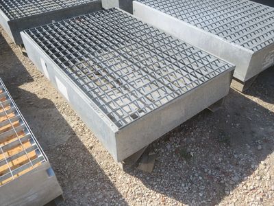 plusieurs grilles en acier sont empilées les unes sur les autres au sol