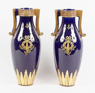 pair of blue and gold vases sitting on a white surface