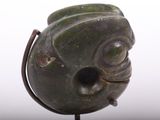 a green sculpture of a fish on a metal stand