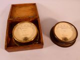 deux horloges posées dans une boîte en bois sur une table