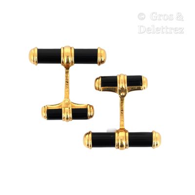 two pairs of black and gold cufflinks with gold accents