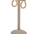 gold hoop earrings on a stand on a white background
