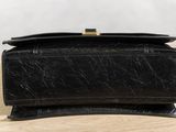 an image of a black purse sitting on top of a wooden table