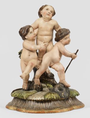 une figurine ancienne représentant trois enfants assis sur un rocher, tenant un bâton