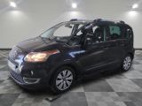 La petite camionnette noire est garée sur un sol en carrelage à damier.